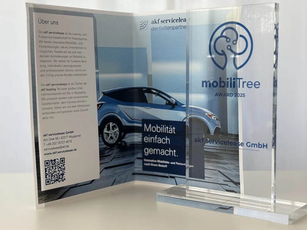 Transparenter Award mit blauem Logo und Schriftzug mobiliTree AWARD 2025 neben aufgeklapptem Flyer mit Bild eines blauen Autos und Texten zu akf servicelease GmbH