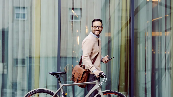 Ein Mann im Anzug fährt Fahrrad und genießt die frische Luft in der Stadt.