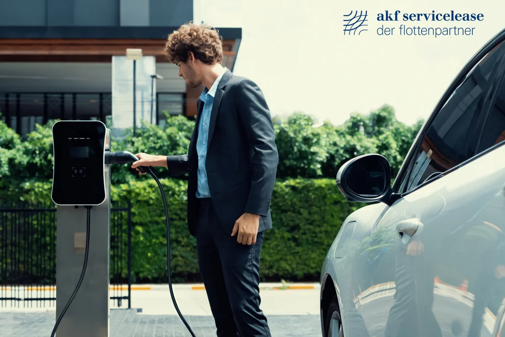 Mann im Anzug lädt Elektroauto an Ladestation auf