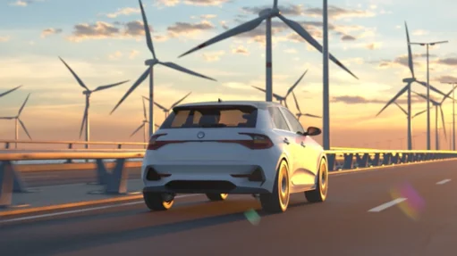 Ein weißes Auto fährt auf einer Brücke mit Windrädern im Hintergrund bei Sonnenuntergang