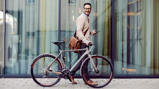 Ein Mann im Anzug fährt Fahrrad und genießt die frische Luft in der Stadt.