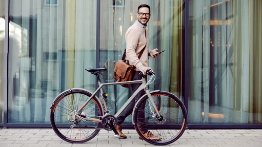 Ein Mann im Anzug fährt Fahrrad und genießt die frische Luft in der Stadt.